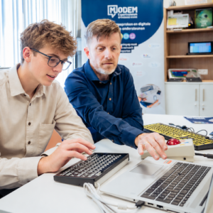 Digitaal schrijven met ondersteuning via laptop, spraakherkenning en aangepaste hulpmiddelen.